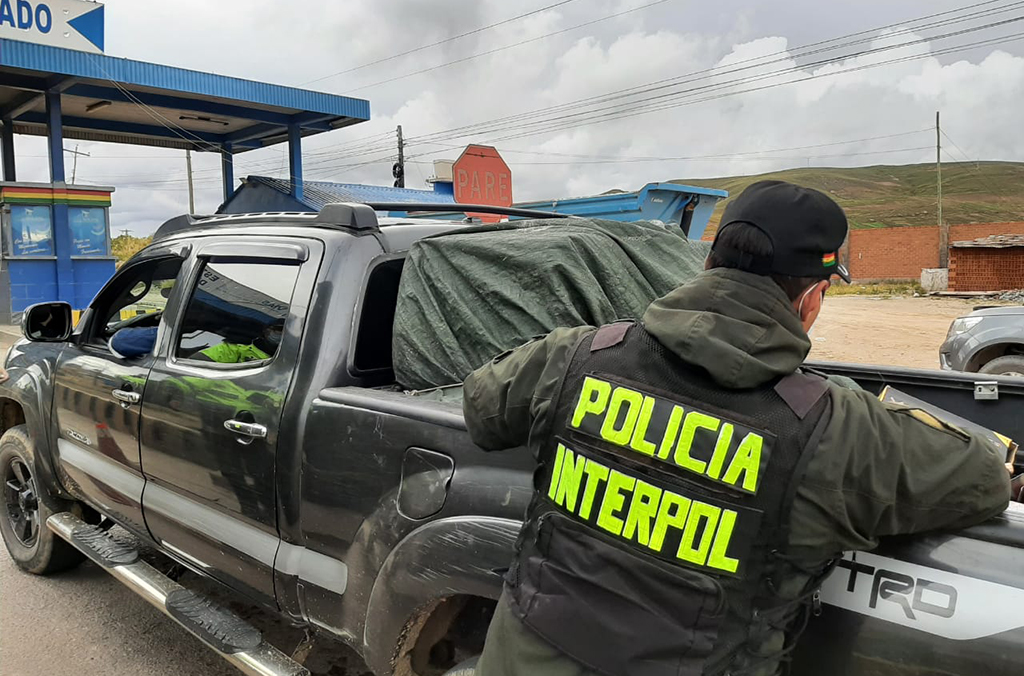 Dans le cadre de l’opération Trigger VI, un policier bolivien fouille un véhicule à un point névralgique présumé du trafic d’armes à feu.